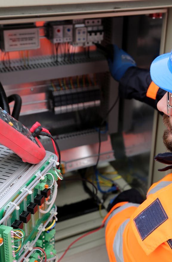 The Art of Drawing Readers In: Your attractive post title goes here Electrician wearing safety gear operates switchboard in industrial setting.